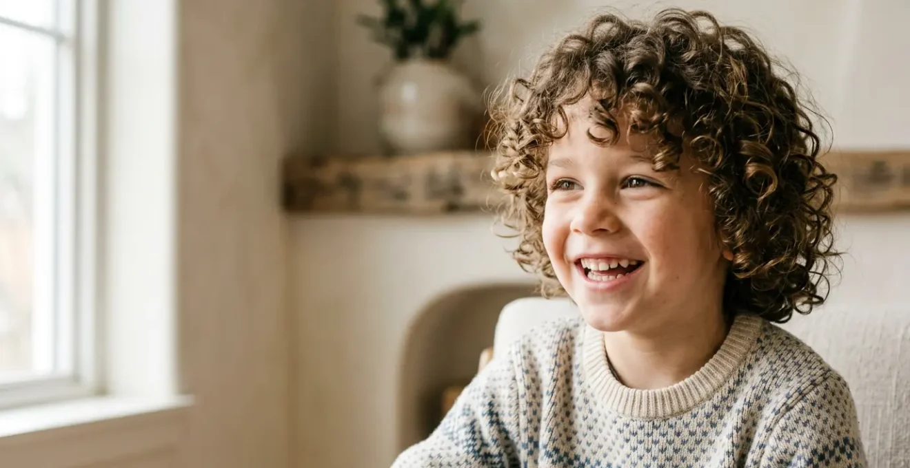 Portrait d'un garçon de 5 ans souriant avec des cheveux bouclés bien définis et naturels, sans aspect cartonné